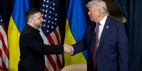 Зеленський і Трамп обмінюються рукостисканням на тлі прапорів України та США