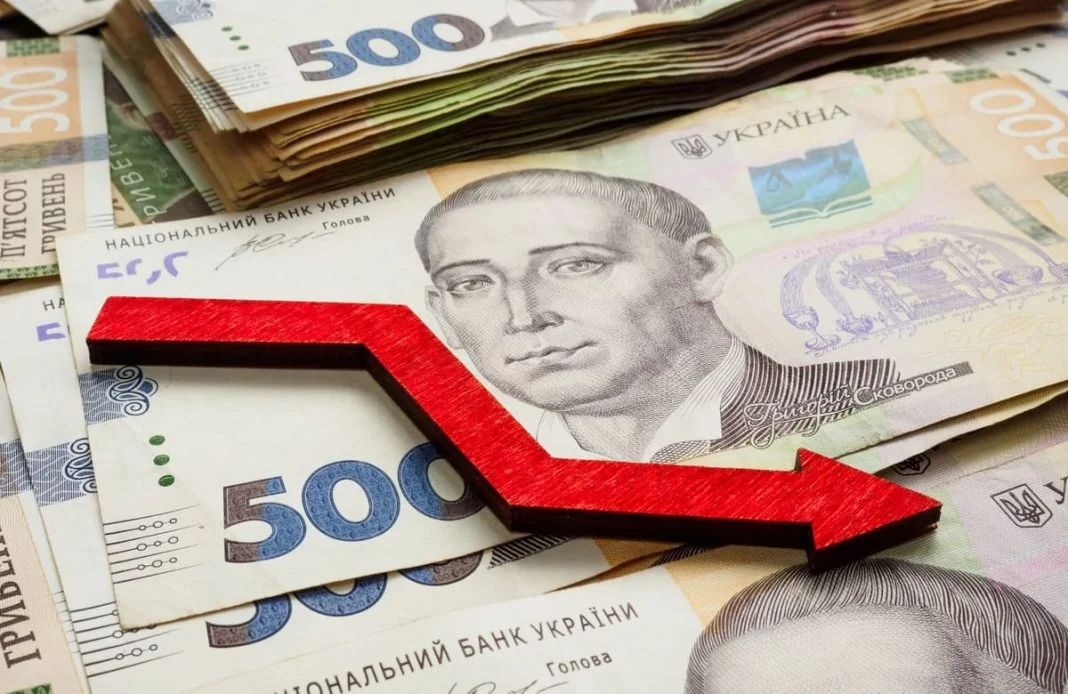 Банкноти 500 гривень зі стрілкою вниз на тлі сповільнення інфляції до 7,2%