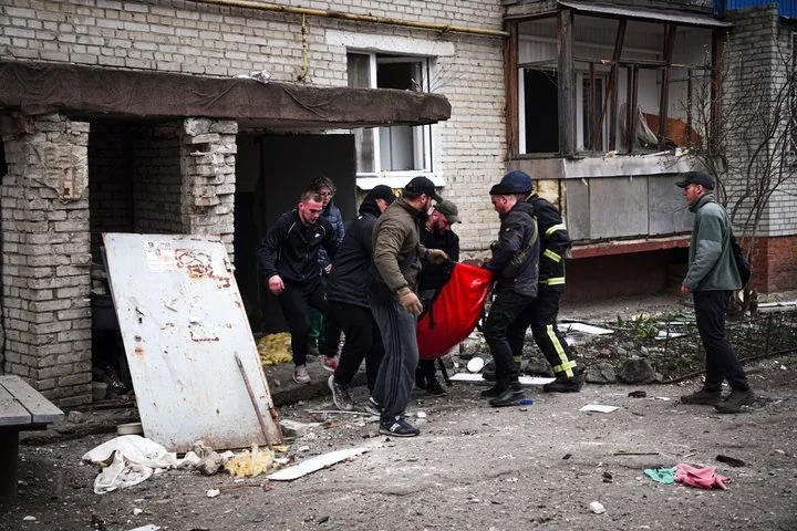 Рятувальники виносять тіло загиблого після удару КАБами в Сумах