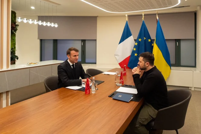 Зеленський і Макрон за столом переговорів з прапорами України та Франції
