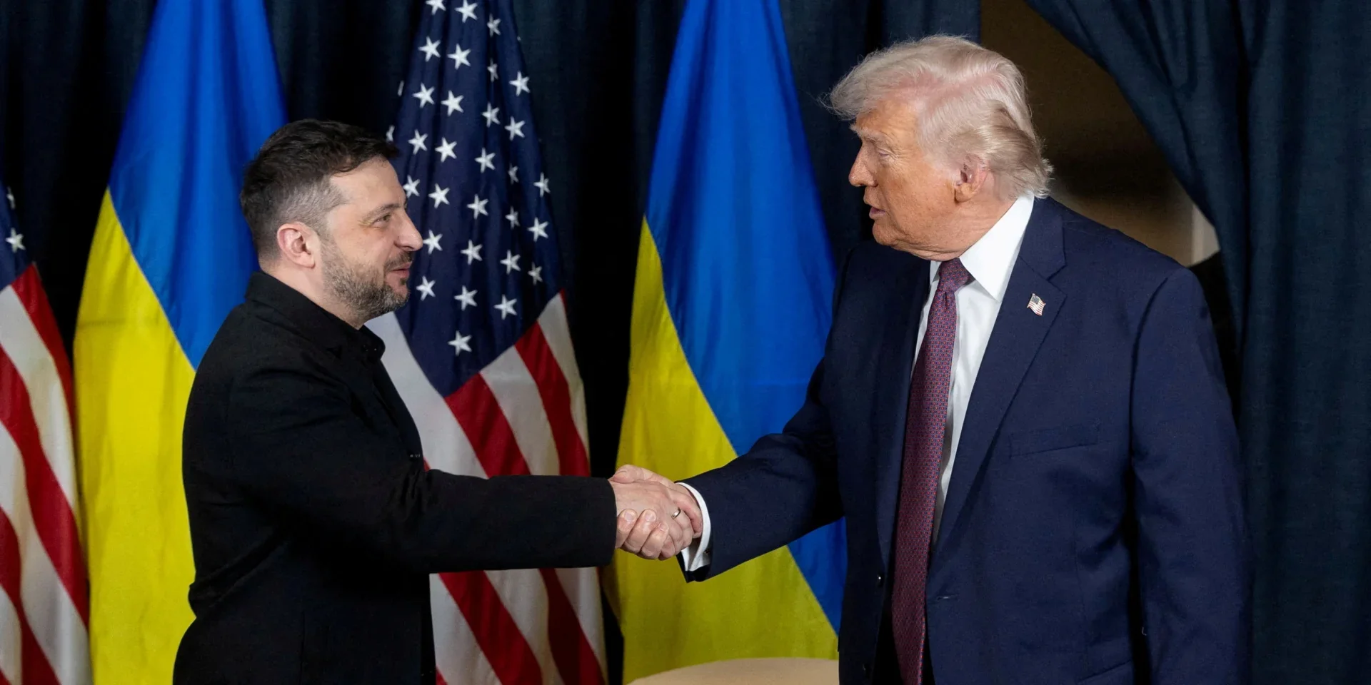 Зеленський і Трамп тиснуть руки на тлі прапорів України та США